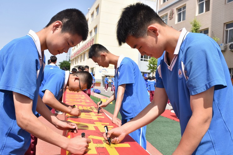 （原創）河北清苑：織密中小學生“防溺水”安全防護網_fororder_同學們在防溺水宣傳橫幅上簽名。 趙琪攝.JPG