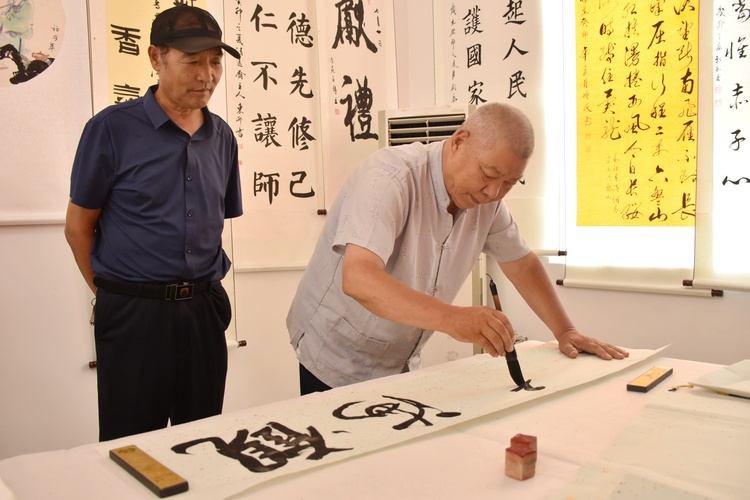 河北清苑：農民書畫展秀出鄉村新風貌_fororder_文藝志願者進行現場創作。 趙琪攝.JPG