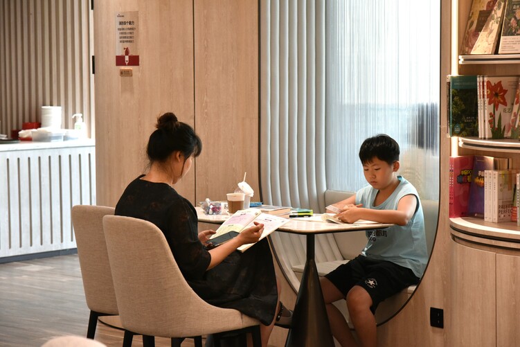 （原創）石家莊裕華區：書城迎來暑期消夏熱_fororder_鐘書閣內，學生在家長的陪同下認真閱讀書籍.JPG