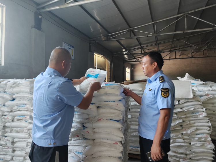 圖片默認標題_fororder_市場監管人員查看食鹽儲存情況 攝影 賈林靜