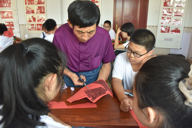 圖片默認標題_fororder_清苑曹莊村剪紙非遺傳承人冉佔水指導中小學生剪紙。劉一諾攝.JPG