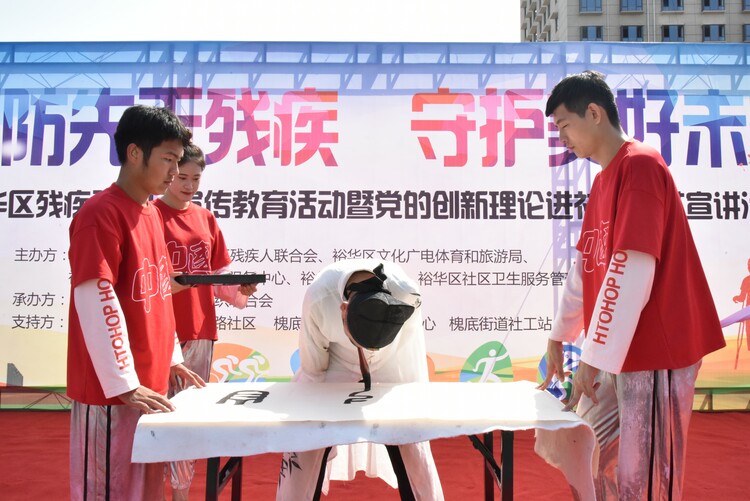 石家莊市裕華區舉辦殘疾預防宣傳教育暨黨的創新理論進社區”文藝宣進活動_fororder_藝術團演員正在書寫毛筆字.JPG