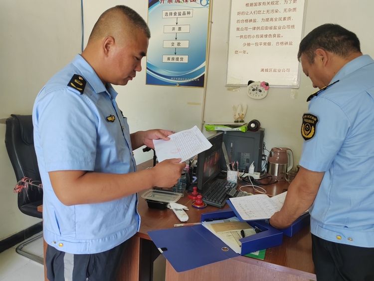 圖片默認標題_fororder_滿城區市場監管人員查看食鹽銷售臺賬 攝影 賈林靜