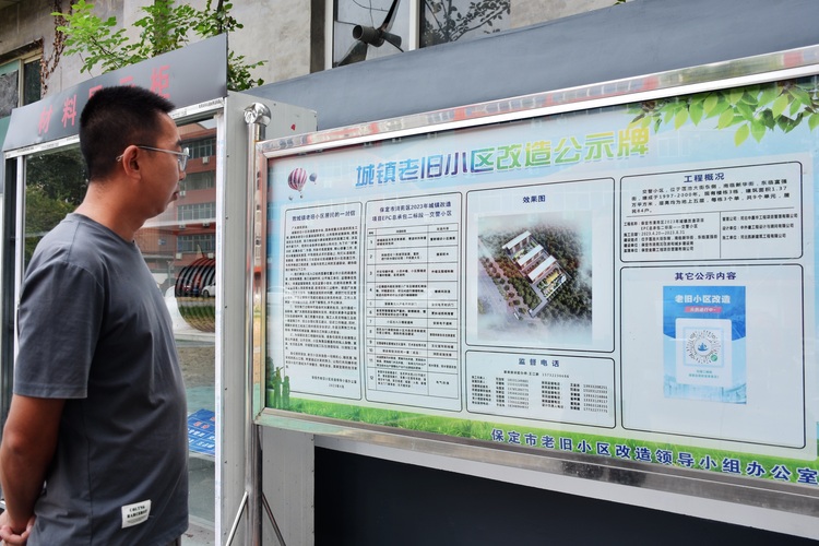 河北清苑：老舊小區改造  提升居民幸福感_fororder_圖五居民查看改造公示牌。趙琪攝.JPG