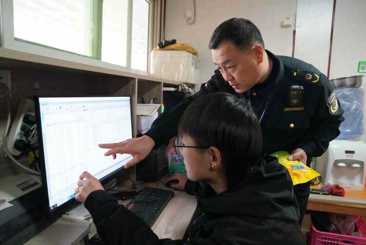 河北清苑：規範農村食品經營 創建首批示範店_fororder_執法人員查驗農村超市食品進貨電子臺賬。攝影 王磊