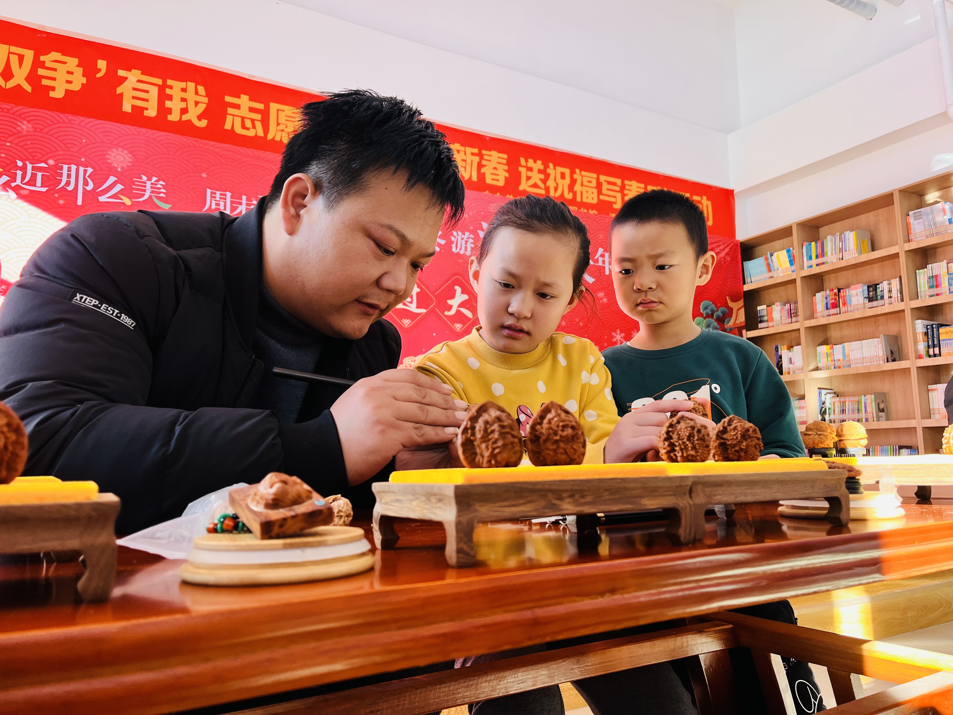 圖片默認標題_fororder_圖為淶水縣圖書館小朋友正在了解核雕非遺技藝。（徐梓鈺攝）