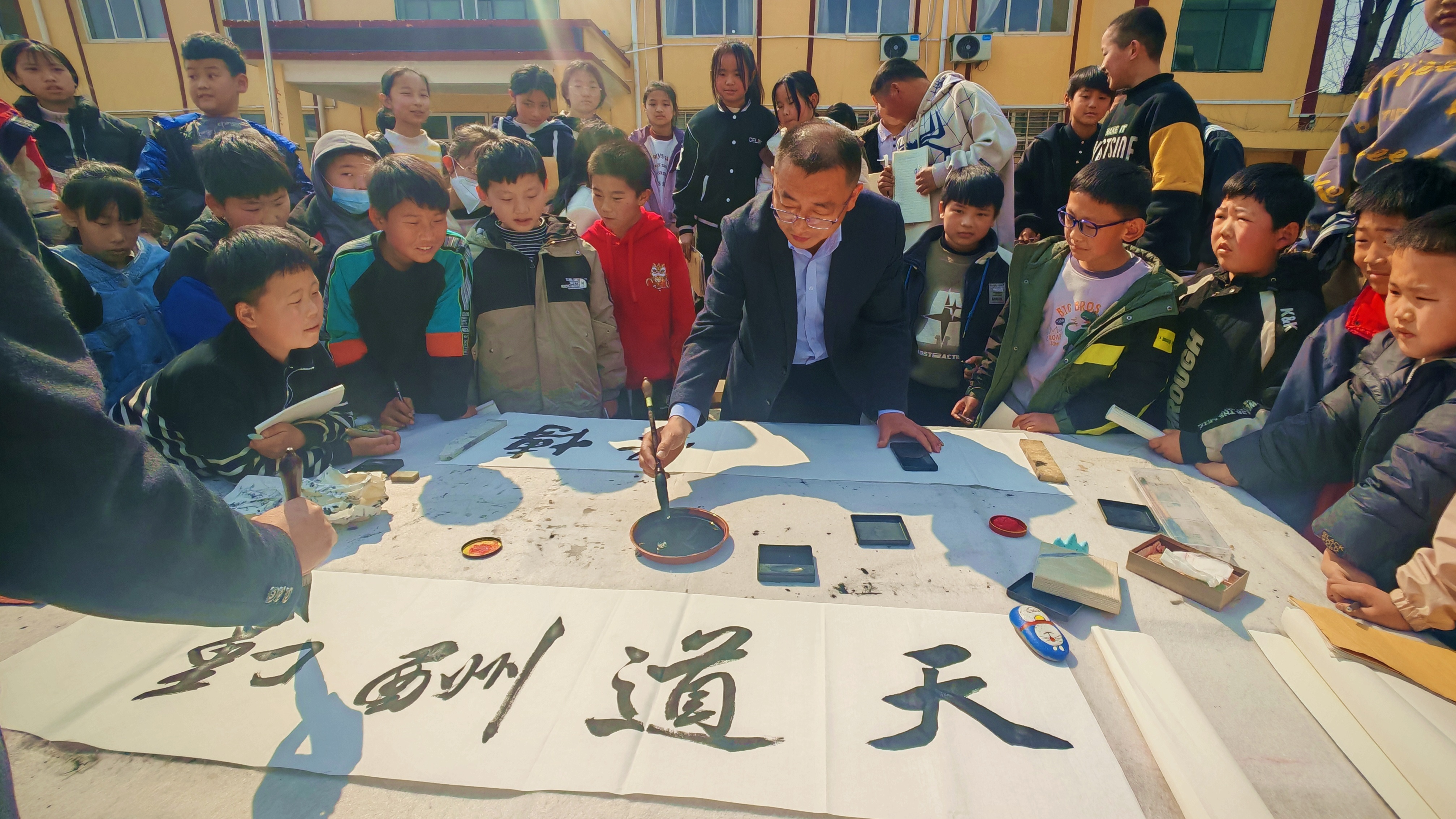 河北唐縣：書法進校園 墨香潤師生_fororder_書法老師們現場為孩子們進行書法展示