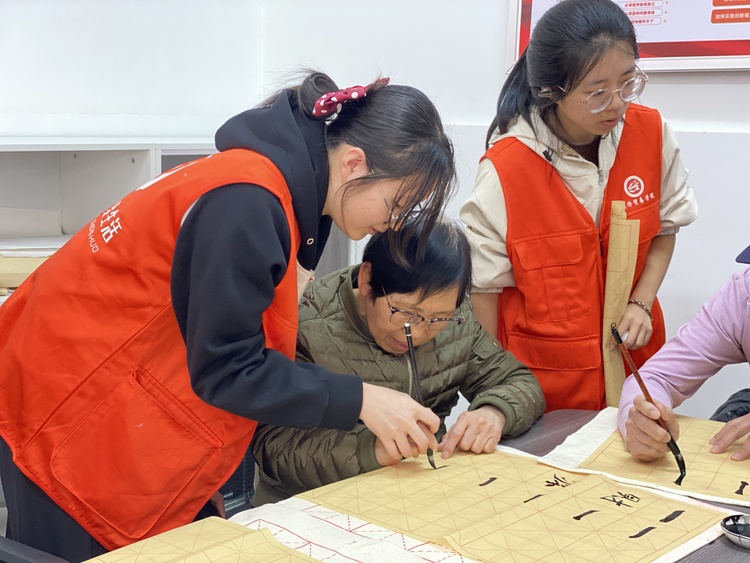 保定市蓮池區：志願服務架起社區與居民的“暖心橋”_fororder_圖片二：清山公爵城社區聯合保定職業技術學院、河北金融學院經濟貿易學院開設“暖心傾城·翰墨飄香”公益書法國畫班。（劉迪攝）