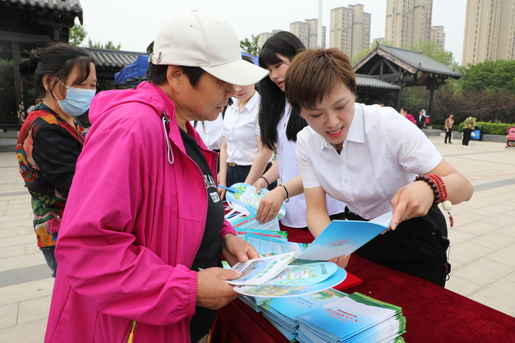 河北淶水：保護生物多樣性 共同守護綠色家園_fororder_圖為工作人員向群眾講解保護生物多樣性的宣傳手冊。（徐梓鈺 攝）.JPG
