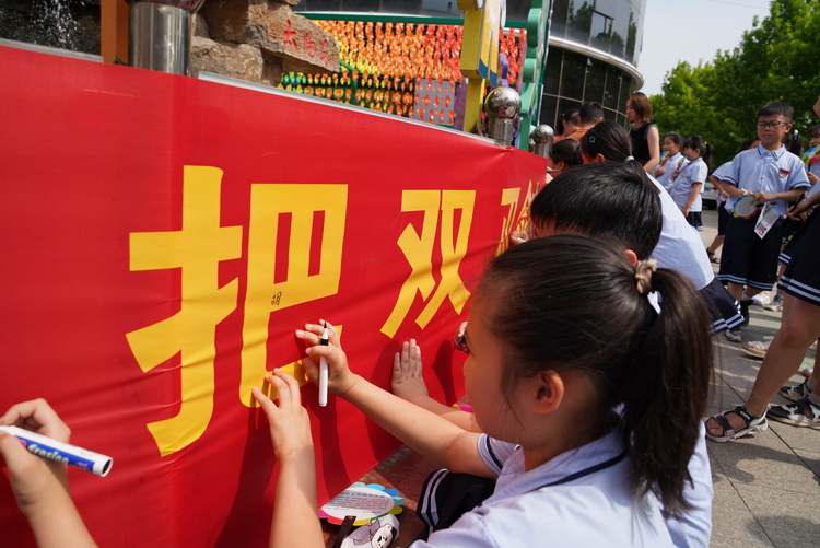 河北承德縣開展“網絡文明與你‘童’行”網絡知識進校園活動_fororder_圖為學生們在“網絡是把雙刃劍，文明使用很關鍵”條幅上簽字。承德縣委網信辦供圖.JPG