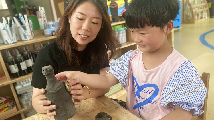 河北唐縣：探秘青銅文化 觸摸歷史之美_fororder_老師正指導孩子製作青銅器模型