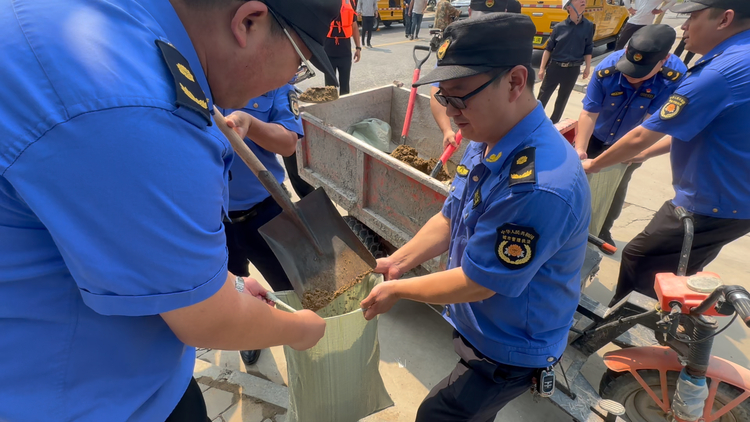 保定蓮池區：枕戈待旦 築牢防汛安全“堤壩”_fororder_圖片一：城市管理綜合行政執法局工作人員裝沙袋。（張倩攝）