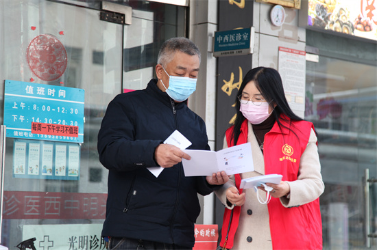 南陽市臥龍區開展《公民防疫行為準則》宣傳冊發放活動_fororder_臥龍區委宣傳部工作人員向居民講解防疫知識 攝影 曹飛