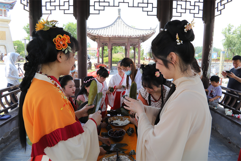 週口鹿邑：端午祭先賢 祈祉佑中華_fororder_（9）2022年6月3日，“端午祭先賢·祈祉佑中華 端午祭祀祈福活動”現場，鹿邑縣民間文藝家協會的民俗專家指導大家體驗包粽子。薛召峰 攝.JPG