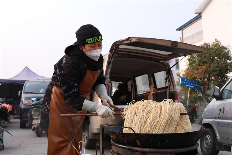 【原創】信陽市浉河區：鄉村大集迎新年_fororder_炸焦馓子的老闆娘，也是一個熱愛勞動的小姐姐。她説，現在的美好生活就十分“香甜”。.JPG