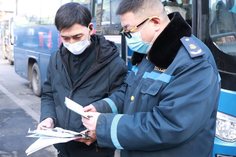 信陽市浉河區：春運保暢進行時_fororder_宋飛（右）正在查驗班車的出站手續.JPG