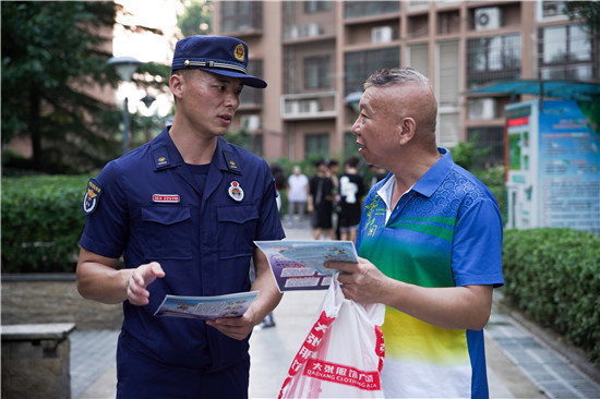 三門峽市湖濱區開展網絡辟謠宣傳進社區活動_fororder_消防指戰員為小區居民講解正規招錄流程 攝影 王保龍