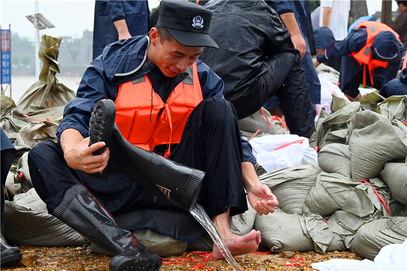 南陽市社旗縣：眾志成城防大汛_fororder_搶險人員倒出膠鞋中的積水 攝影 申鴻皓