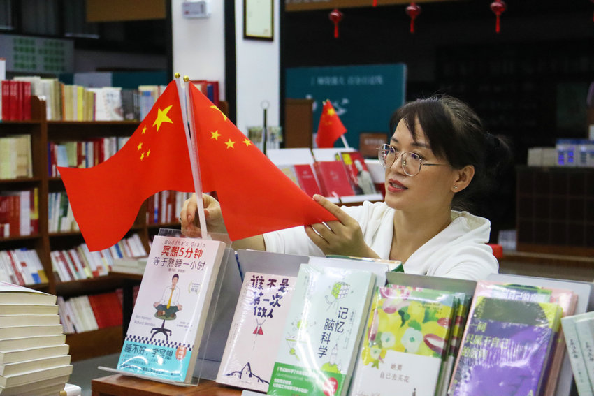 南陽市臥龍區：國慶中秋節日氛圍濃_fororder_書店工作人員在擺放國旗 攝影 王小軍.JPG