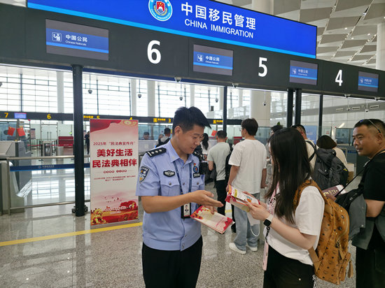 “鄭”值濃情端午節 鄭州邊檢守國門優服務護口岸穩序運轉_fororder_鄭州邊檢站民警向旅客宣講法律知識（王晗攝）