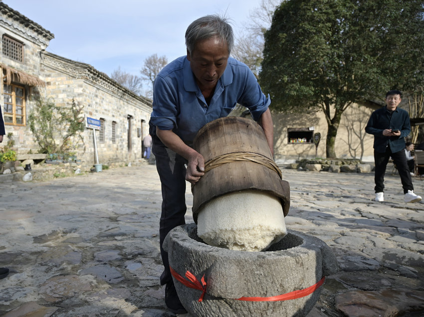 信陽市新縣：古村糍粑香  民俗韻味長_fororder_將蒸好的糯米倒進石臼中（焦漢平 攝）