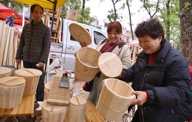 信陽市新縣：非遺大市集熱鬧開市_fororder_群眾正在挑選木制生活用品（焦漢平 攝）