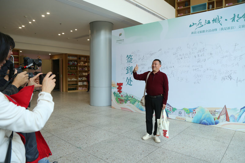 信陽市新縣舉辦文旅推介活動 向全國遊客發出冬季邀約_fororder_簽名墻前拍照（王麗君 攝）