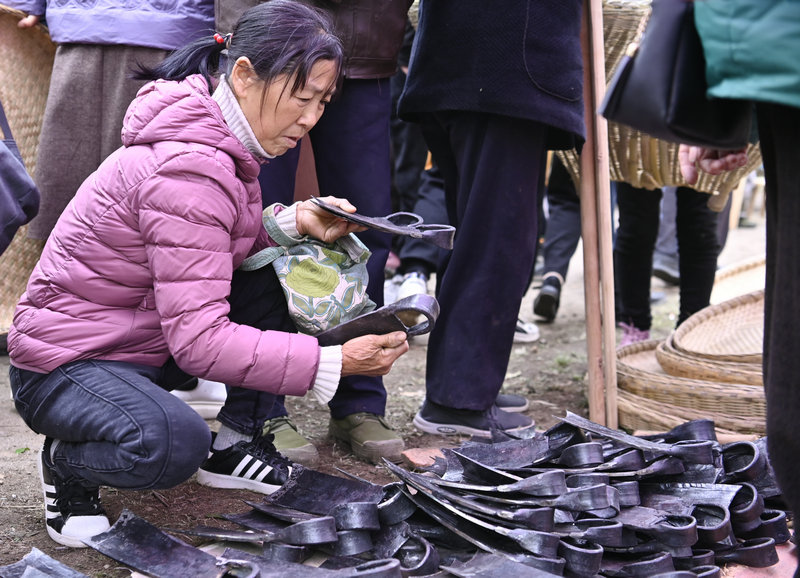信陽市新縣：非遺大市集熱鬧開市_fororder_群眾正在認真挑選農具（焦漢平 攝）