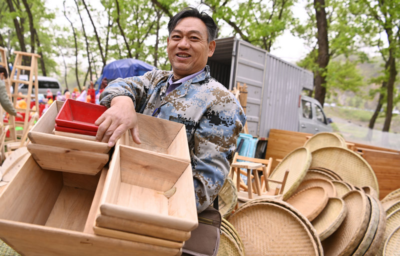 信陽市新縣：非遺大市集熱鬧開市_fororder_攤主展示他的手工製品(焦漢平 攝)