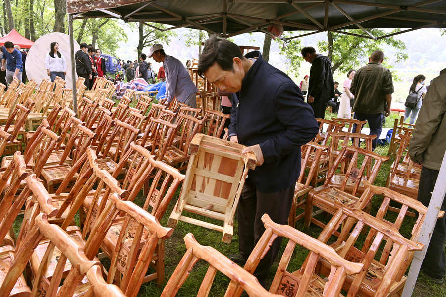 信陽新縣：“非遺大市集”火熱開市_fororder_遊客正在挑選凳子（焦漢平 攝）