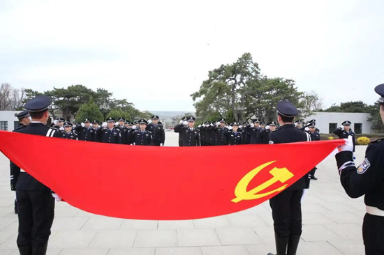 鞍山市公安局舉行“傳承紅色記憶•祭奠革命先烈”清明祭奠活動_fororder_全體民警面對鮮紅的黨旗再一次重溫入黨誓詞 供圖：鞍山市公安局