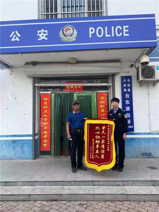 鞍山市臺安縣公安局：兄妹失聯數十載 民警幫忙促團圓_fororder_王長琴（左）將一面寫有“警民一家情誼厚、熱親協助尋親人”的錦旗送給台東派出所民警王洋（右） 供圖 臺安縣公安局