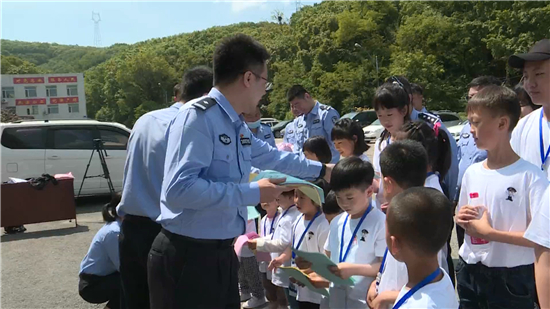 鞍山市公安局開展特色“六一”兒童節主題活動_fororder_警察爸爸為寶貝們配發了反詐小志願者胸牌及反詐傳單，授予他們“反詐小衛士”稱號。攝影：馬威