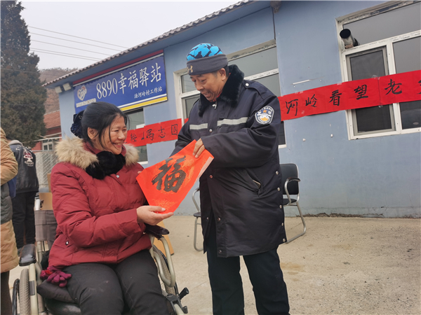 鞍山馮志國愛心團隊走進大山送溫暖 28年奉獻換來愛的延續_fororder_馮志國為卜玉琴送福字 攝影 董楠楠