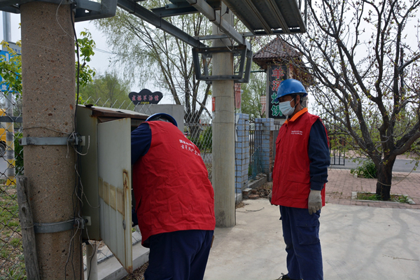 國網瀋陽供電公司：“電”亮鄉村旅遊_fororder_沈北新區供電公司清水街道供電所黨員服務隊在滿族風情小鎮一條街檢查電力設備