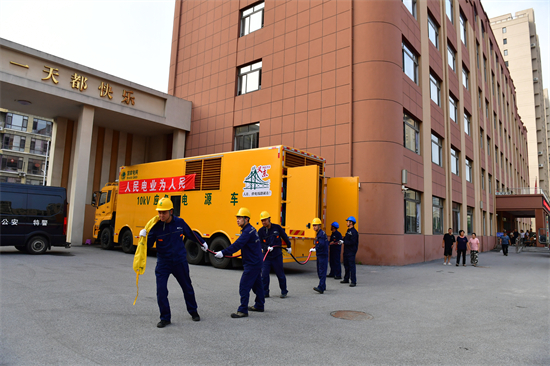 洪峰過境 國網丹東供電公司堅決守牢城市生命線和民生用電底線_fororder_在丹東振安區九連城鎮五緯路小學安置點供電人員在為安置點應急電源.JPG