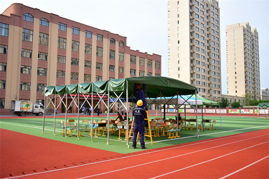 洪峰過境 國網丹東供電公司堅決守牢城市生命線和民生用電底線_fororder_在丹東振安區九連城鎮五緯路小學安置點供電人員在為安置點保障照明供電.JPG