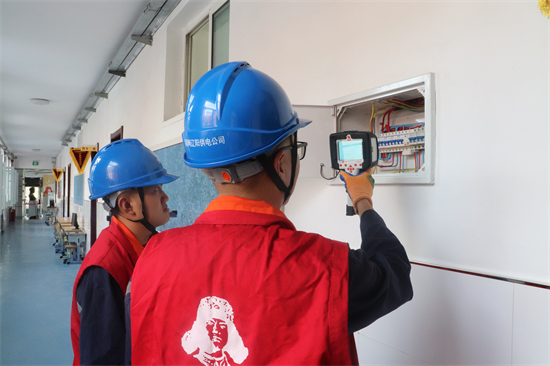國網遼陽供電公司激活校園安全引擎_fororder_弓長嶺區公司員工利用紅外測溫儀開展校園用電安全檢查。（高嘉習）