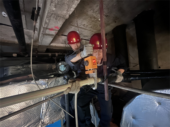 方大集團中興商業暖通科:為消費者築起“溫暖屏障”_fororder_在狹小的棚頂裏,中興商業暖通科員工在聚精會神地檢修設備-2 攝影:徐晨