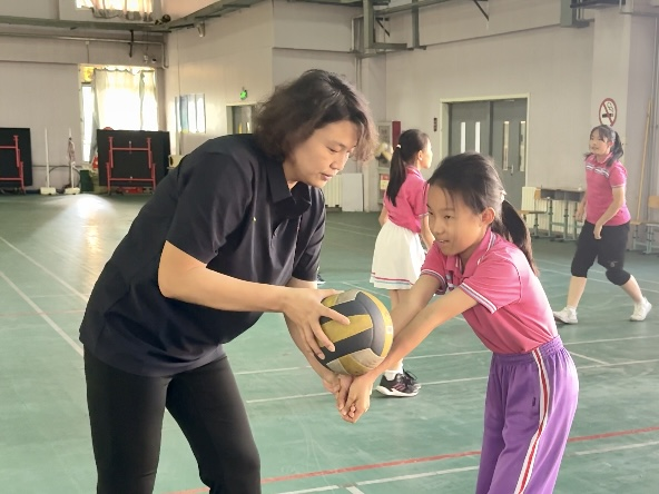 燃動排球夢！天津女排退役名將走進育嬰裏小學 傳承女排精神_fororder_退役運動員柳春瑩對育嬰裏小學排球運動員進行指導