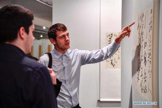 Des visiteurs devant une calligraphie chinoise au siège de l'UNESCO à Paris, en France, le 11 décembre 2017. Environ 50 pièces du calligraphe chinois Zhang Xuguang y sont présentées. (Chen Yichen)