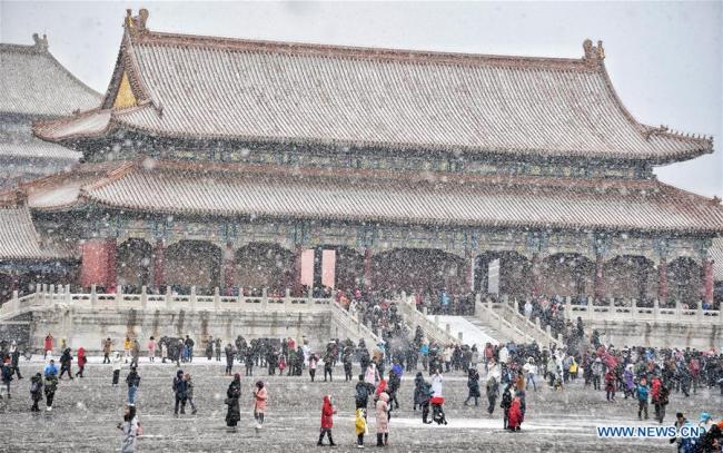 Des touristes admirent la Cité interdite enneigée à Beijing, capitale de la Chine, le 14 février 2019. Jeudi, une chute de neige a frappé Beijing. (Xinhua/Li Xin)