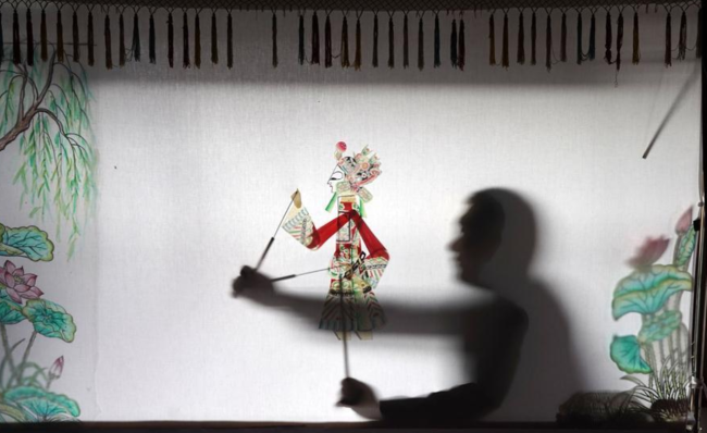 Guo Bao spielt ein Schattenspiel in seinem Museum.