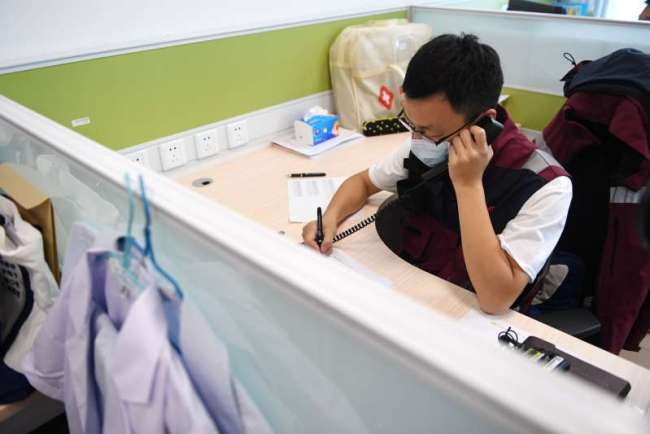 Li Ruoxi macht einen Telefonanruf in seinem Büro<br>Foto von Xinhua