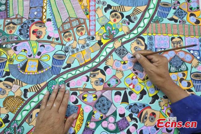 Ζωγράφος(畫家Huàjiā )της εθνότητας των Μιάο ζωγραφίζει στο χωριό Πινγκπό της κομητείας Λονγκλί της Αυτόνομης Νομαρχίας Τσιεννάν Μπουγί και Μιάο, στην επαρχία Γκουιτζόου της νοτιοδυτικής Κίνας, στις 15 Σεπτεμβρίου 2021