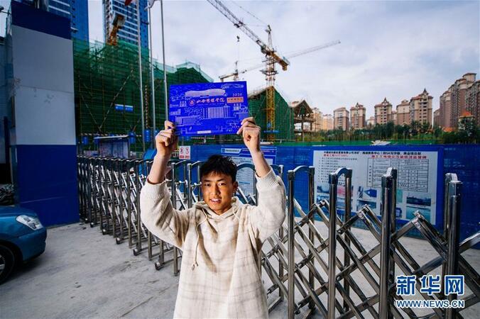 9月16日,在青海省西寧市某建築工地門口,才讓東智展示自己的大學錄取通知書。新華社記者 劉金海 攝