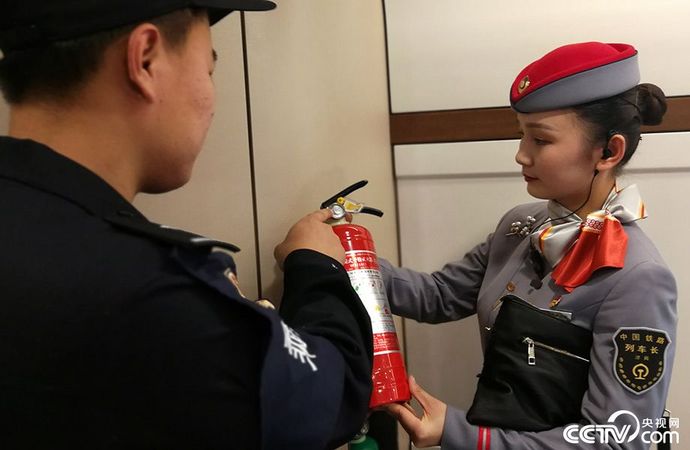 除了對乘客行李等物品進行安檢外,高鐵列車上的滅火器、應急錘等應急安全工具也必須保證能正常使用。圖為李沙沙與乘警一起查看滅火器相關參數。