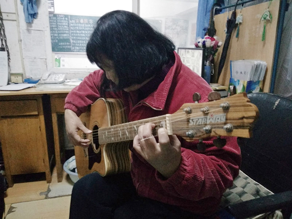 Zhang Chuanyun practices playing guitar at Wuchang Shouyi University in Wuhan, capital of Hubei Province. [Photo: thepaper.cn]