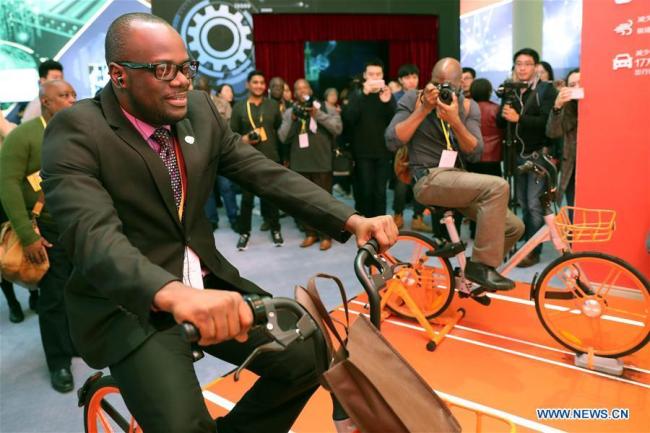 Un journaliste teste un vélo en libre-service au Centre des expositions de Beijing, capitale de la Chine, le 16 octobre 2017.