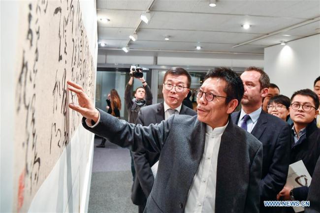 Zhang Xuguang (au premier plan) présente une de ses calligraphies au siège de l'UNESCO à Paris, en France, le 11 décembre 2017. Environ 50 pièces du calligraphe chinois Zhang Xuguang y sont présentées. (Chen Yichen)